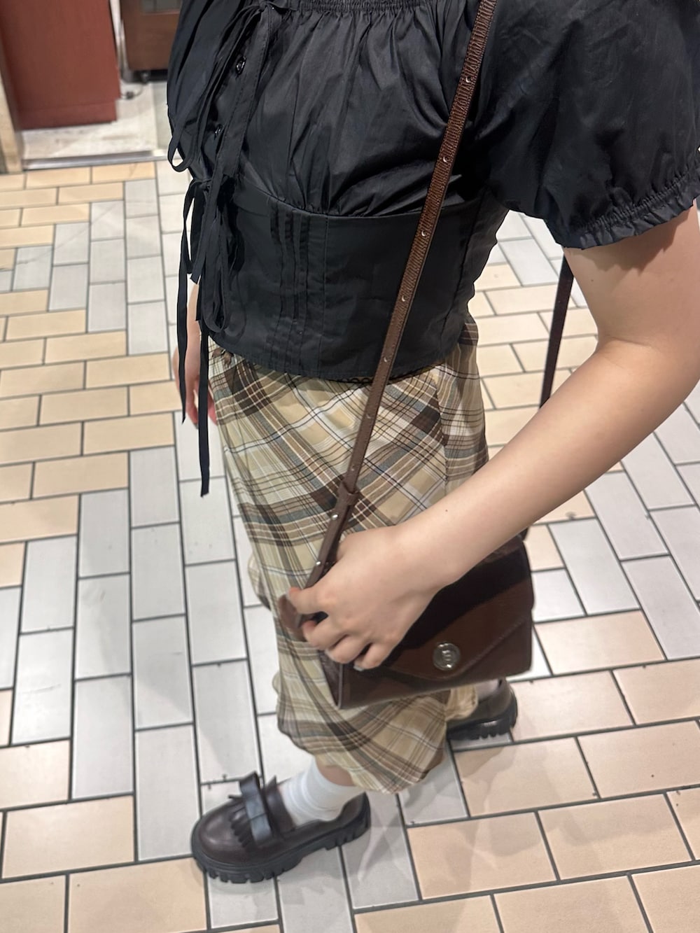 ブラック系のシャツ/ブラウス、ブラウン系のスカート、ブラウン系のローファーを着用したレディースの夏コーディネートの4枚目の写真