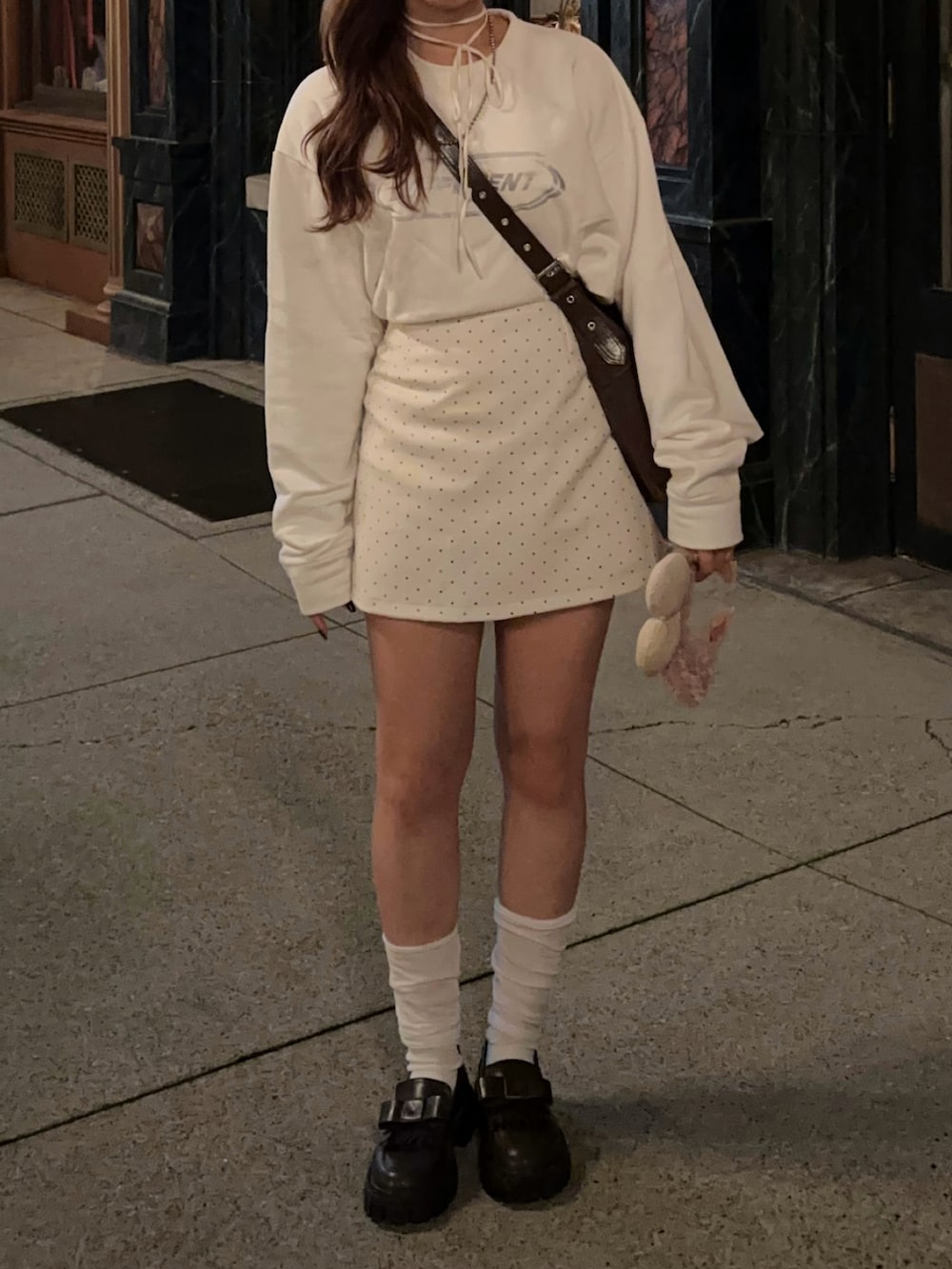 ホワイト系のスカート、ブラウン系のローファーを着用したレディースの秋コーディネートの2枚目の写真