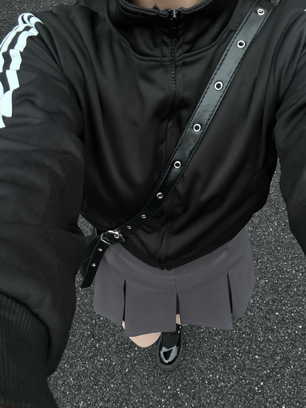 グレー系のスカート、ブラック系のジャージ、ブラック系のショルダーバッグを着用したレディースの冬コーディネートの3枚目の写真