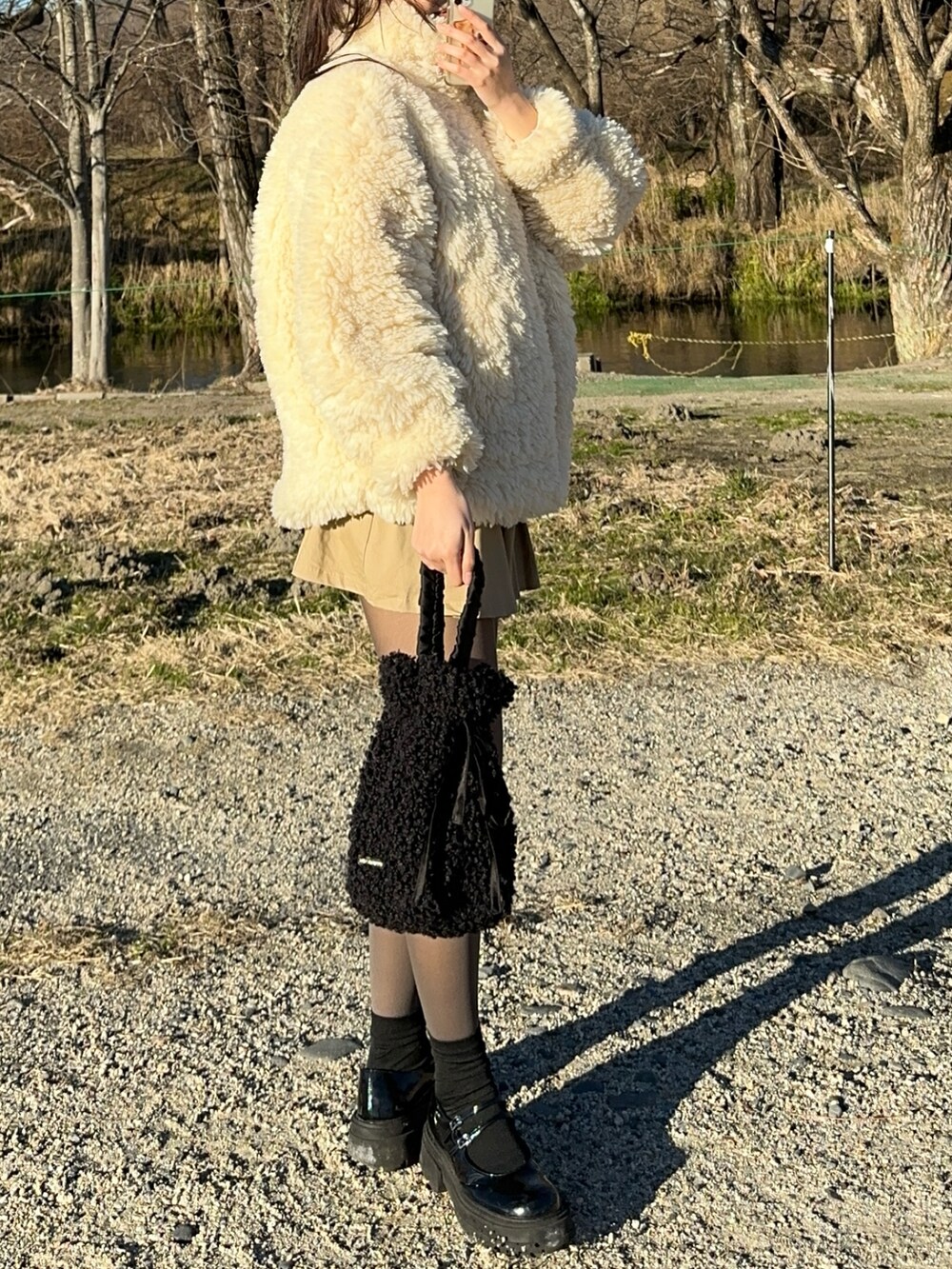 ベージュ系のその他アウター、ブラック系のハンドバッグ、ブラック系のパンプスを着用したレディースの冬コーディネートの3枚目の写真