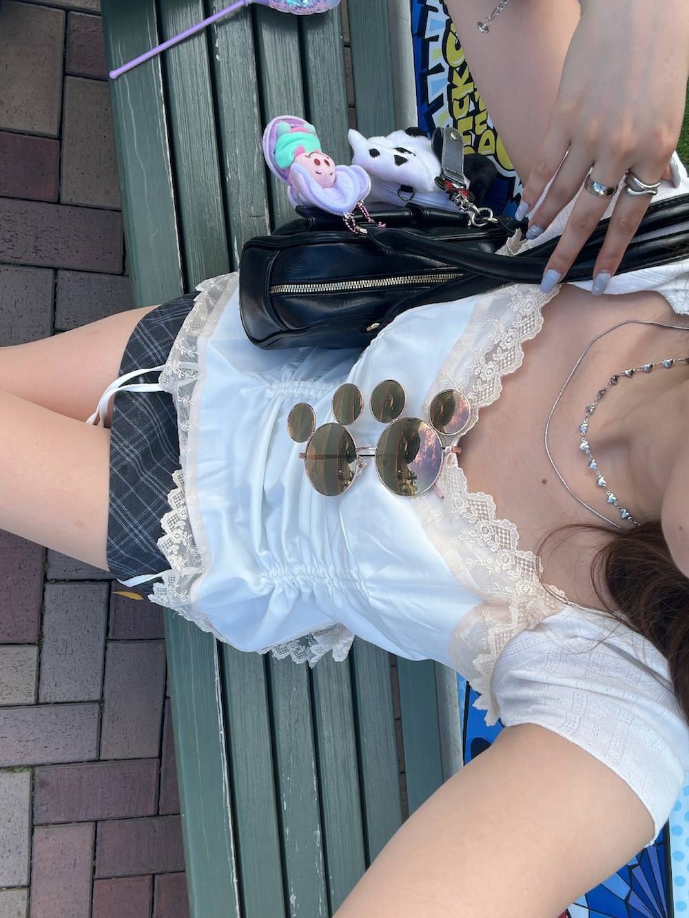 ブラック系のローファー、グレー系のスカート、ブラック系のハンドバッグを着用したレディースの夏コーディネートの2枚目の写真