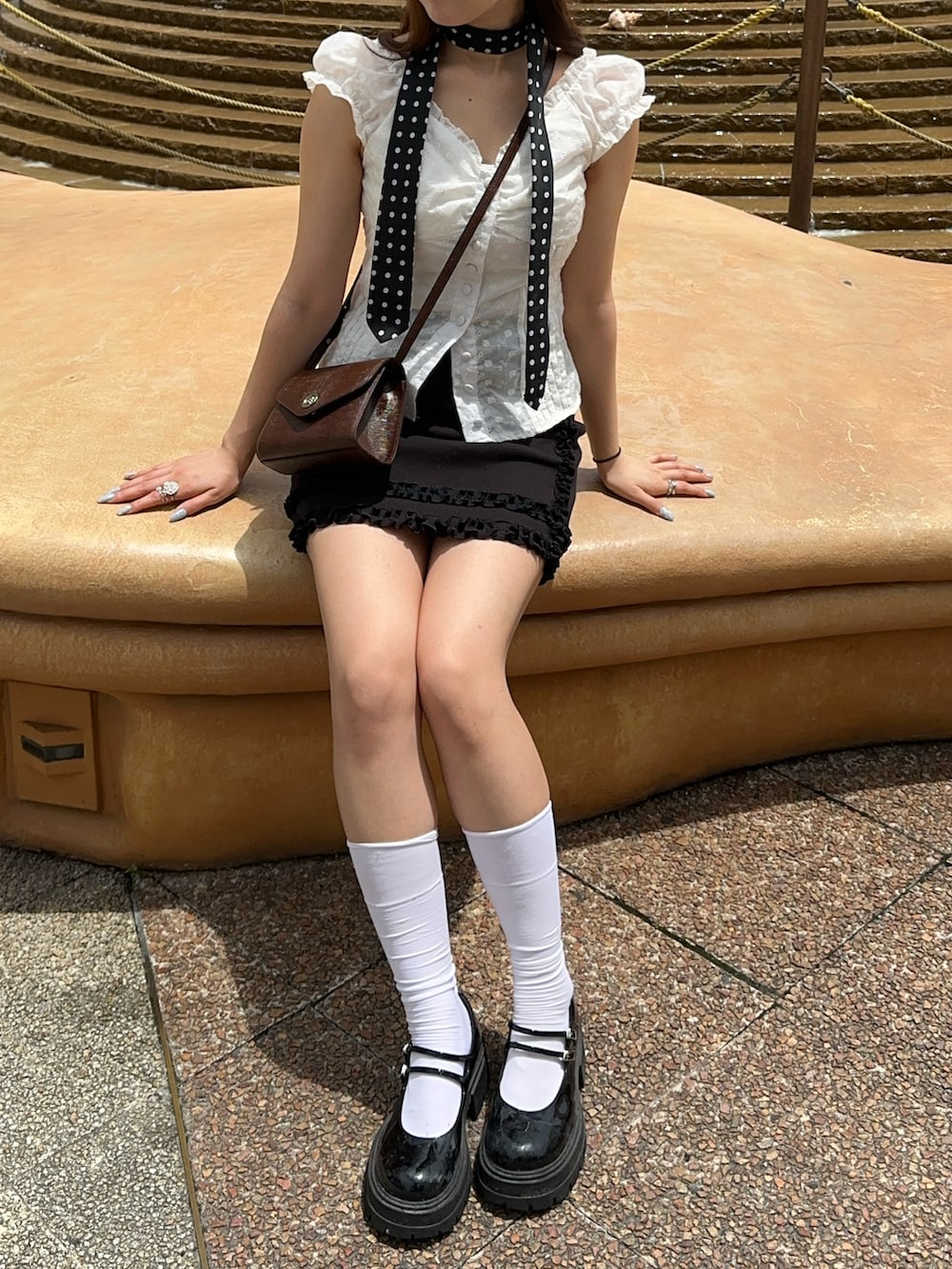 ホワイト系のシャツ/ブラウス、ブラック系のスカート、ブラック系のパンプスを着用したレディースの夏コーディネートの3枚目の写真