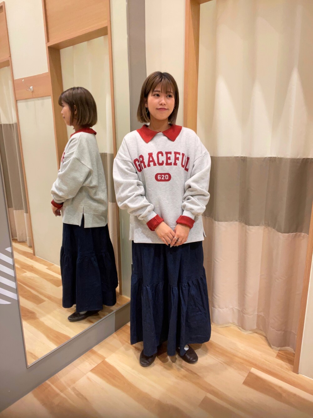 ブルー系のデニムスカート、グリーン系のカーディガン/ボレロ、ホワイト系のスウェットを着用したレディースの秋コーディネートの2枚目の写真