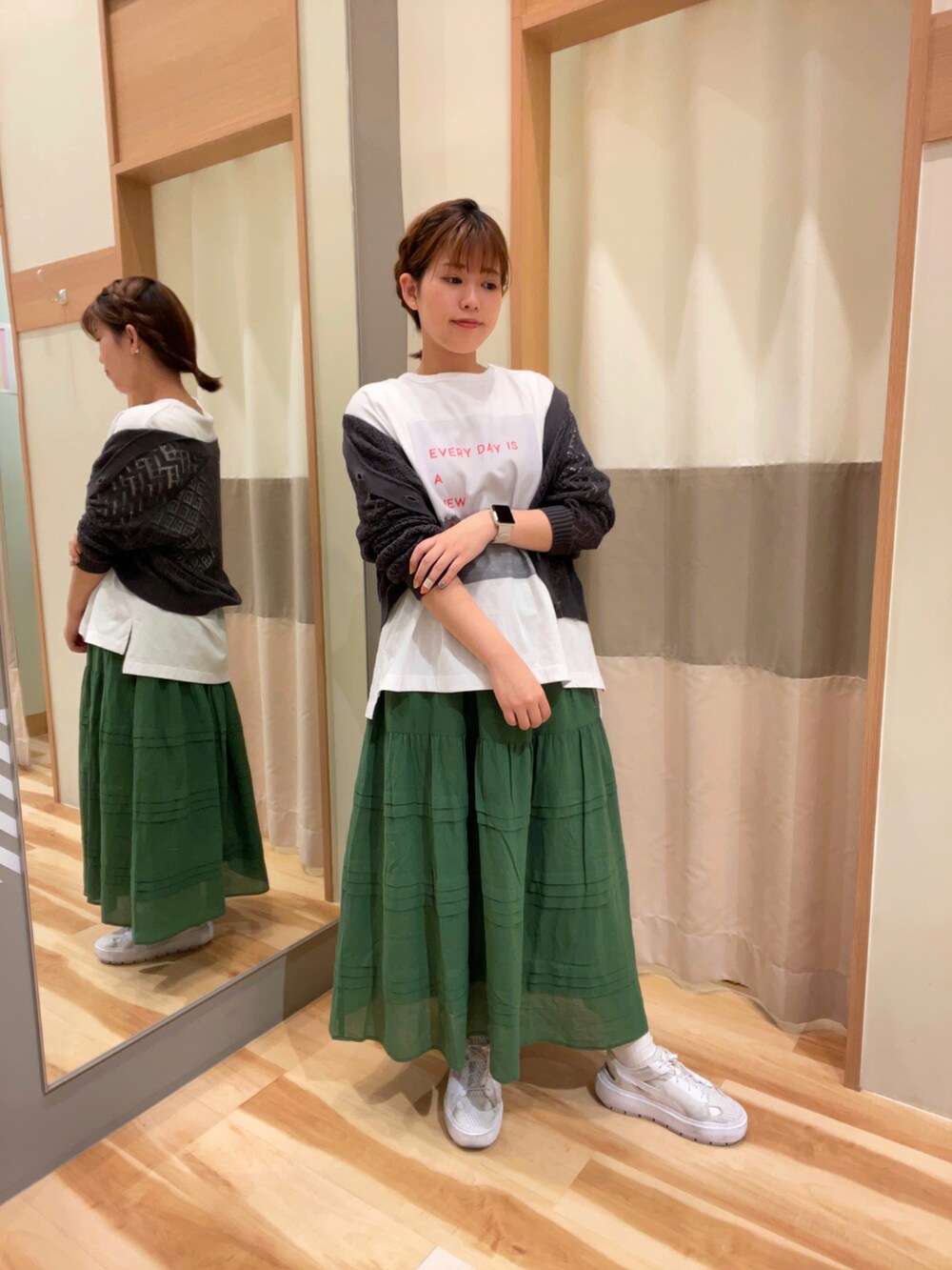 ホワイト系のスニーカー、グリーン系のスカート、ホワイト系のTシャツ/カットソーを着用したレディースの春コーディネートの3枚目の写真