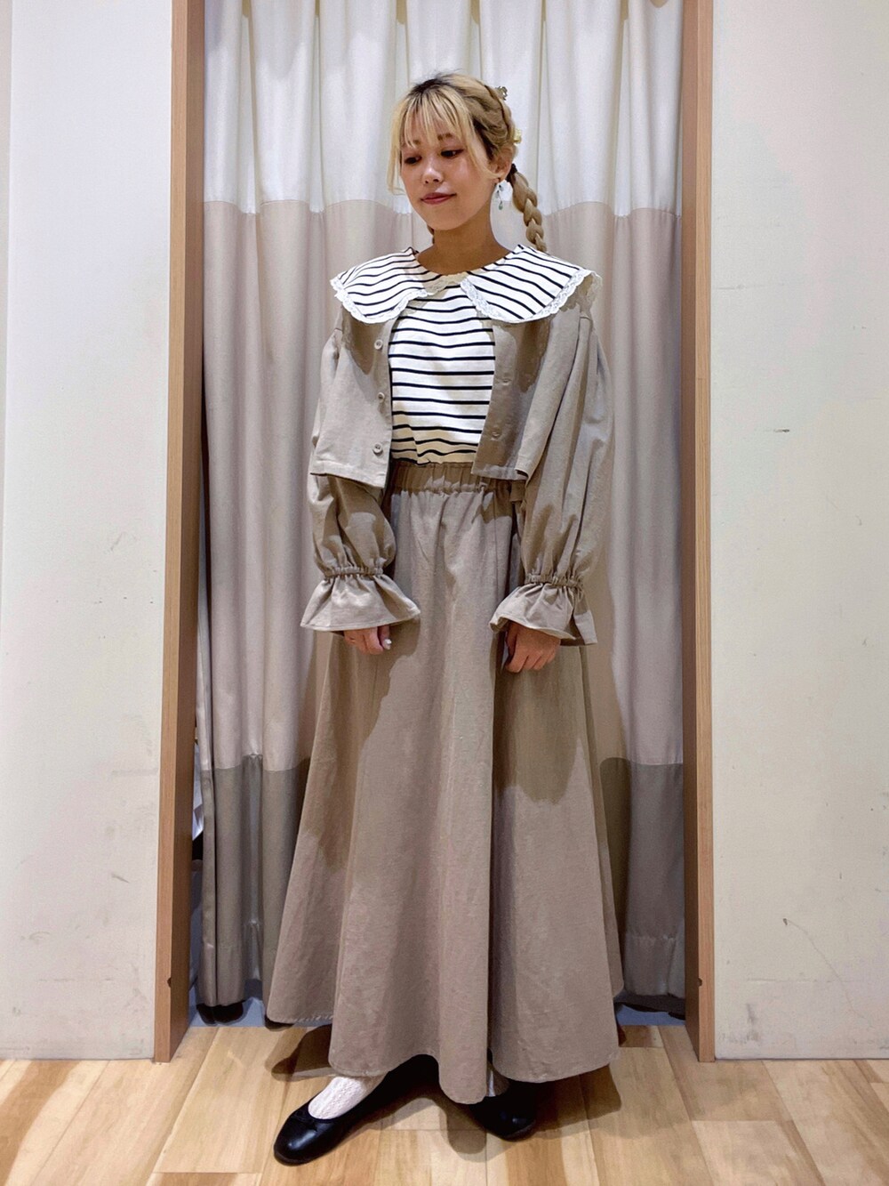 ベージュ系のスカート、ベージュ系のノーカラージャケット、ホワイト系のTシャツ/カットソーを着用したレディースの秋コーディネートの2枚目の写真