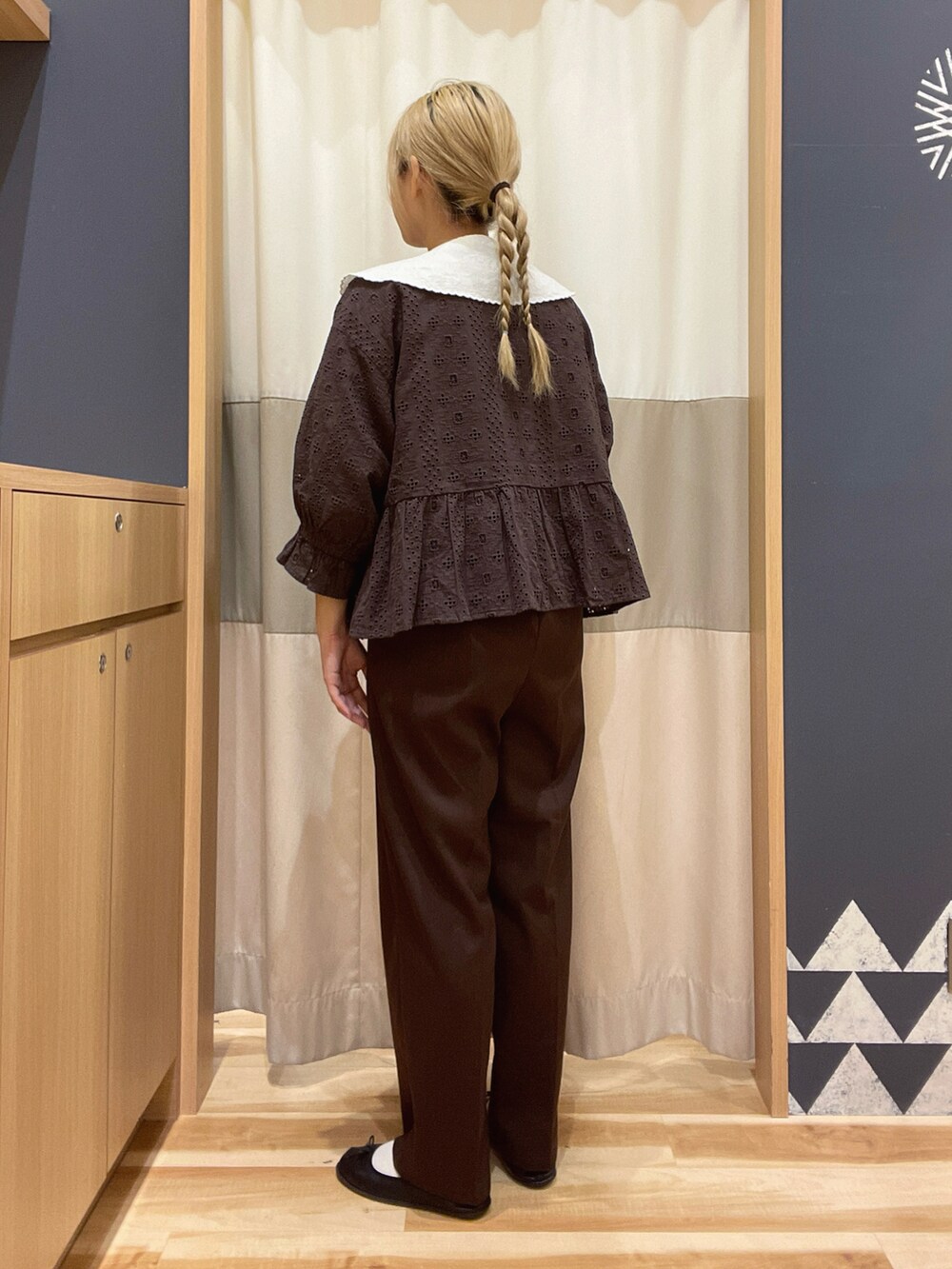 ブラウン系のスラックス、ブラウン系のノーカラージャケット、ホワイト系のシャツ/ブラウスを着用したレディースの春コーディネートの2枚目の写真