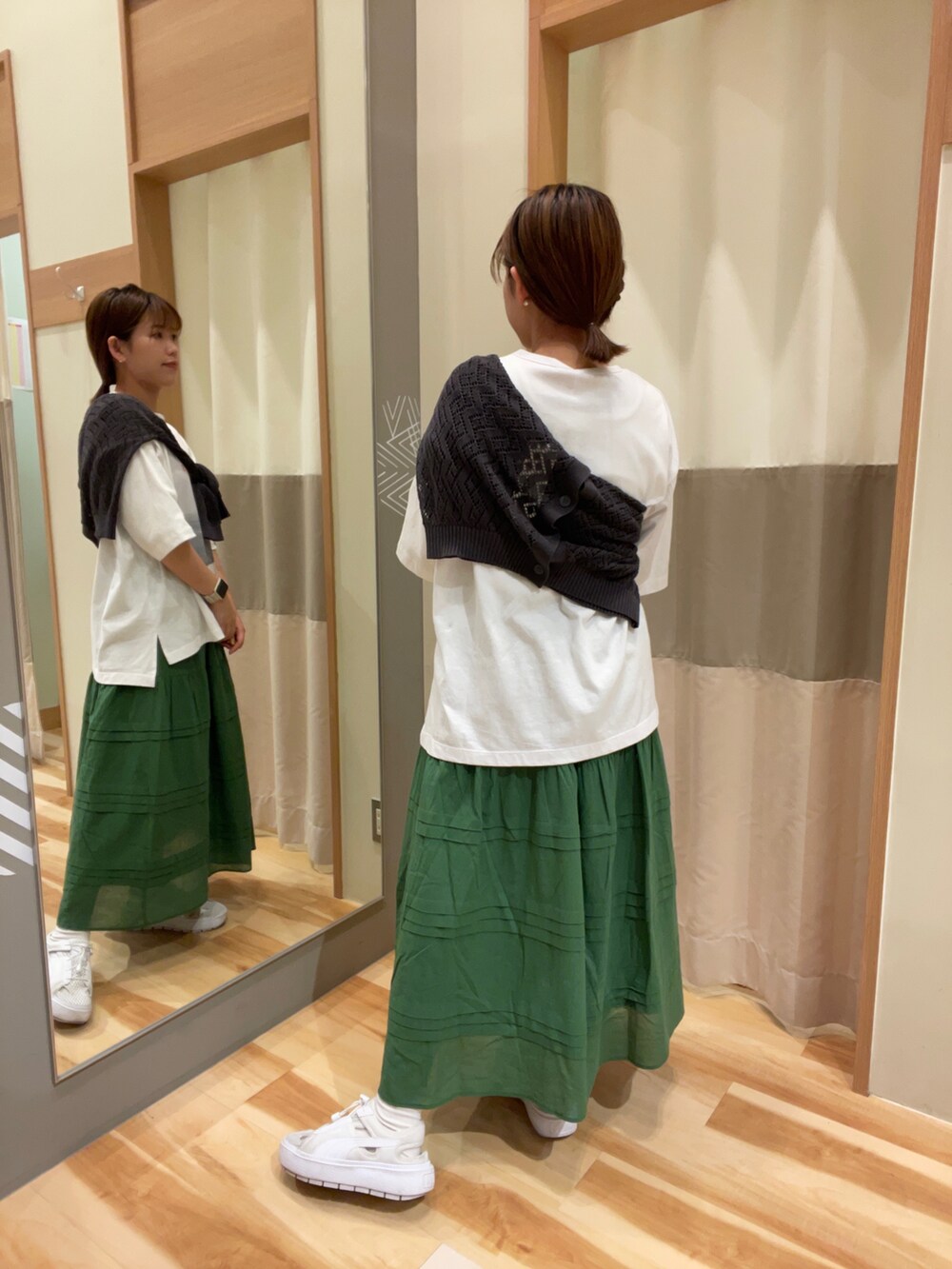 ホワイト系のスニーカー、グリーン系のスカート、ホワイト系のTシャツ/カットソーを着用したレディースの春コーディネートの2枚目の写真