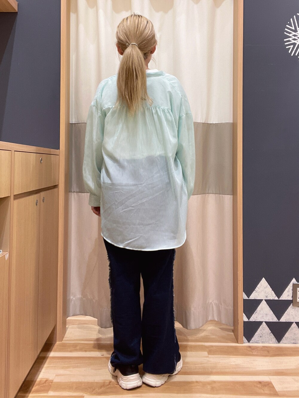 ブルー系のデニムパンツ、ホワイト系のTシャツ/カットソー、グリーン系のシャツ/ブラウスを着用したレディースの春コーディネートの3枚目の写真