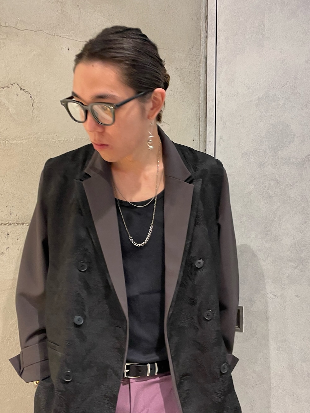 パープル系のスラックス、ブラック系のベスト、ブラウン系のテーラードジャケットを着用したメンズの夏コーディネートの3枚目の写真