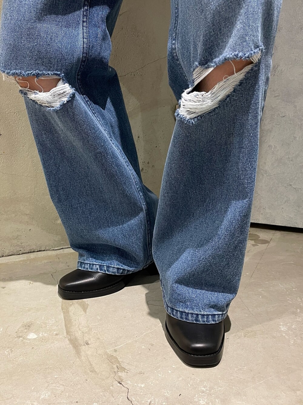 イエロー系のカーディガン/ボレロ、ブラック系のライダースジャケット、ブルー系のデニムパンツを着用したメンズの秋コーディネートの3枚目の写真