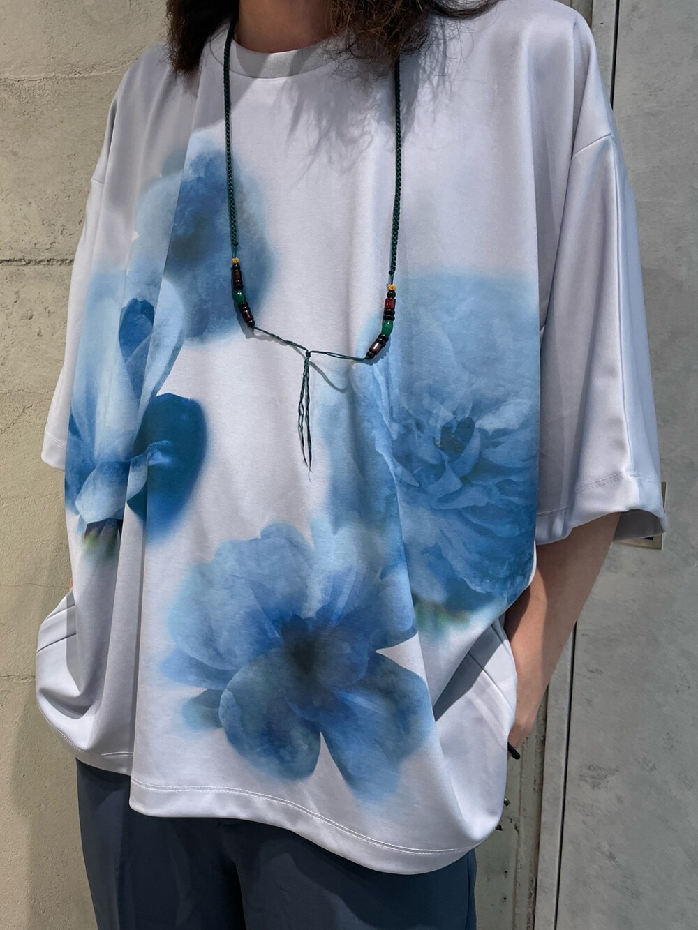 グレー系のTシャツ/カットソー、ブルー系のスラックスを着用したメンズの夏コーディネートの2枚目の写真