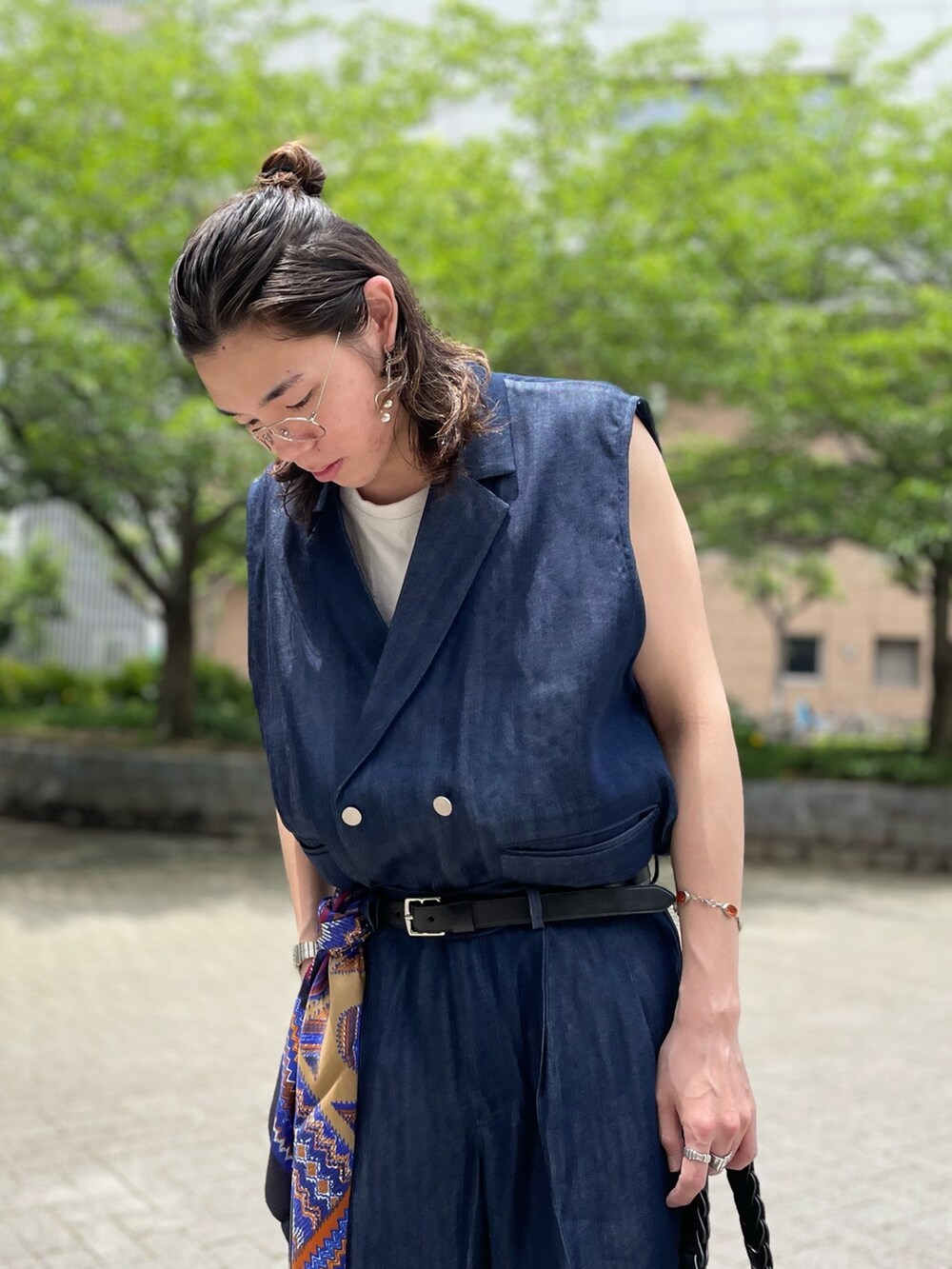 ブルー系のベスト、ブルー系のデニムパンツ、ブラック系のハンドバッグを着用したメンズの夏コーディネートの2枚目の写真