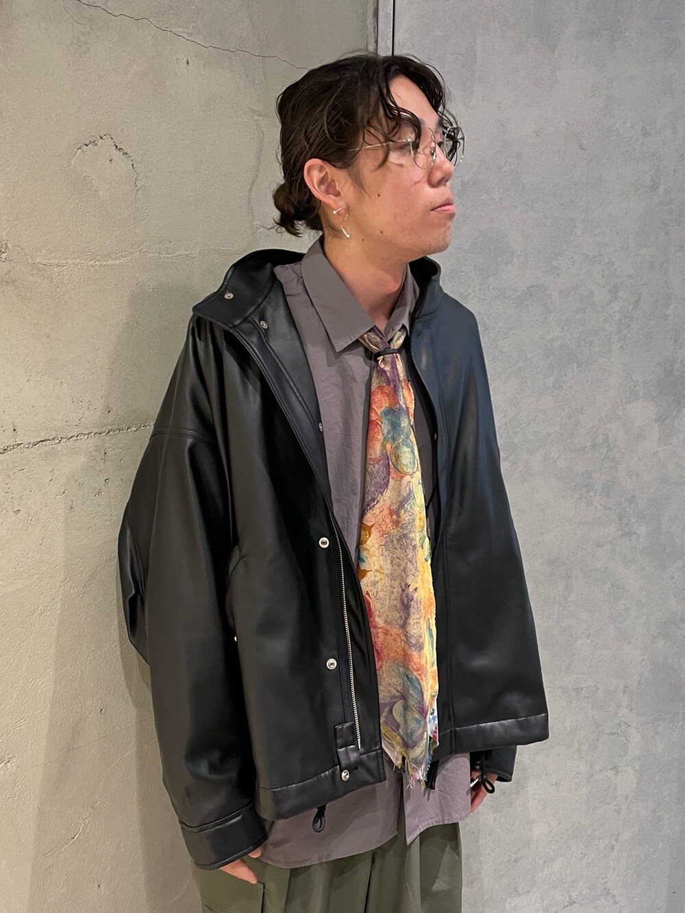 ブラック系のライダースジャケット、ベージュ系のシャツ/ブラウス、グリーン系のカーゴパンツを着用したメンズの秋コーディネートの2枚目の写真