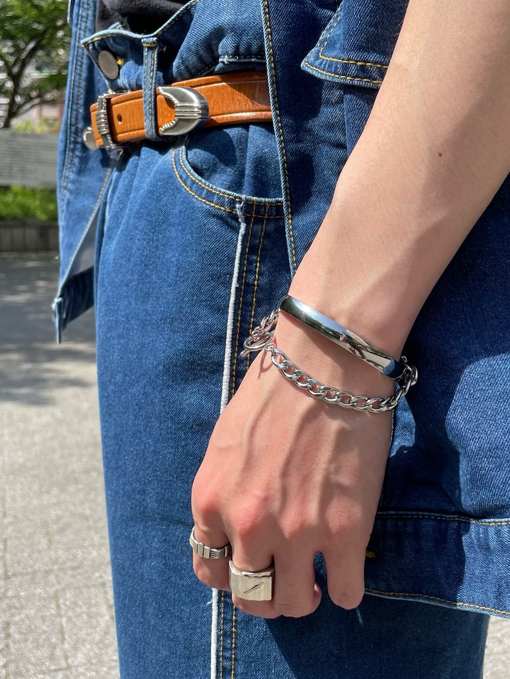 ブルー系のベスト、ブラック系のタンクトップ、ブルー系のデニムパンツを着用したメンズの春コーディネートの5枚目の写真