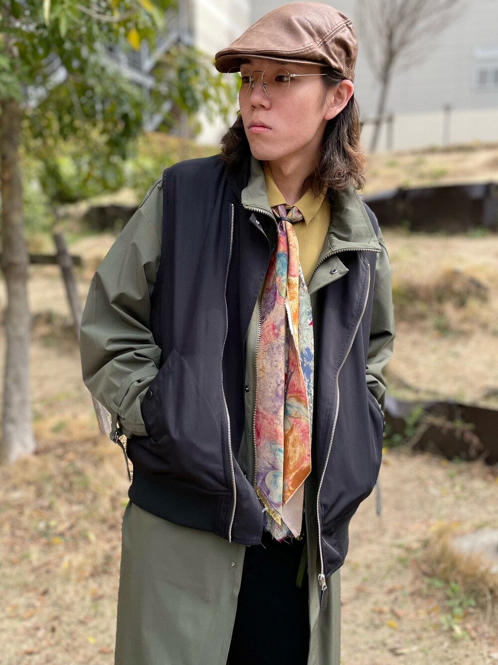 ブラック系のベスト、グリーン系のモッズコート、イエロー系のシャツ/ブラウスを着用したメンズの春コーディネートの3枚目の写真