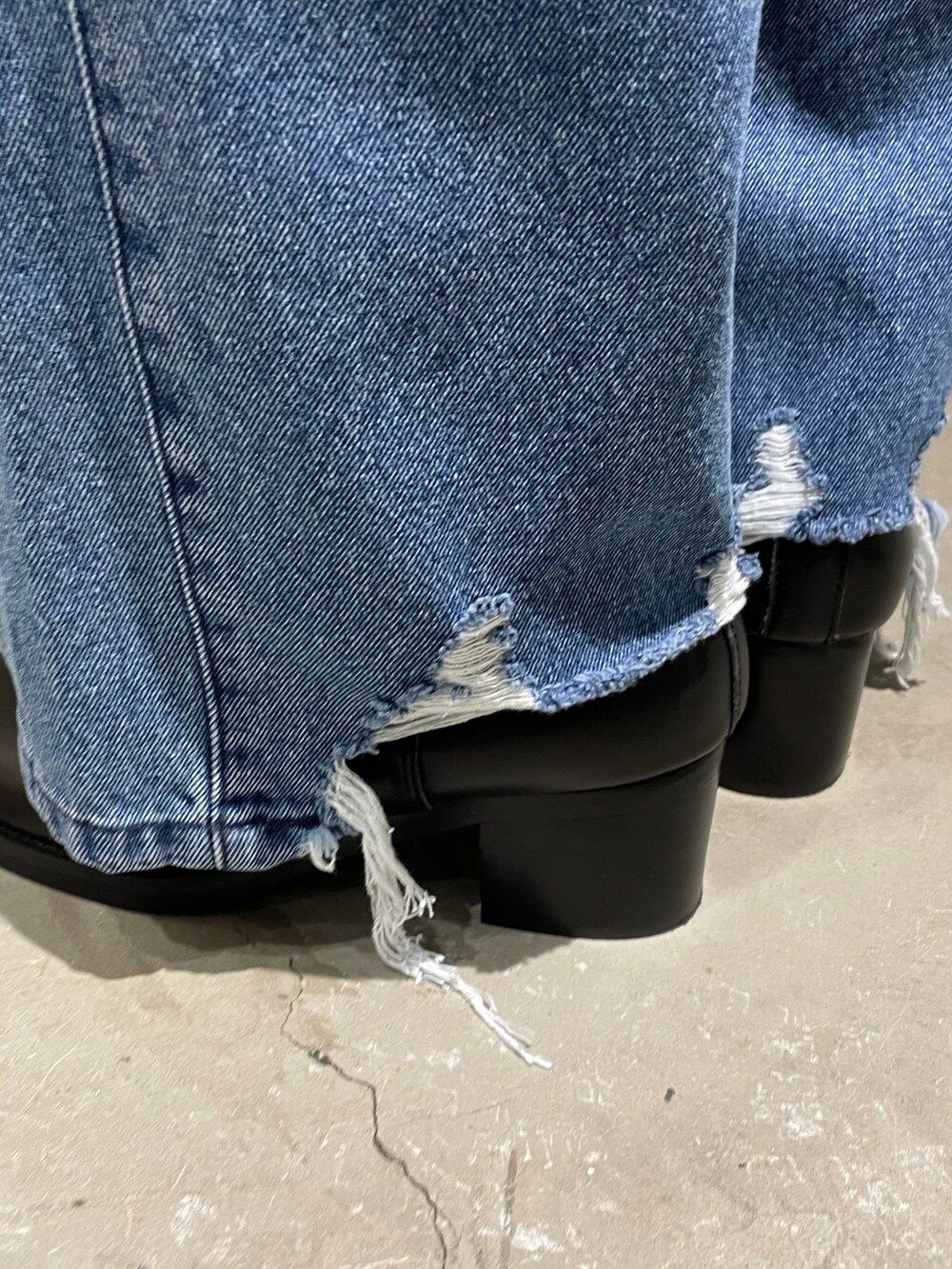 イエロー系のカーディガン/ボレロ、ブラック系のライダースジャケット、ブルー系のデニムパンツを着用したメンズの秋コーディネートの4枚目の写真