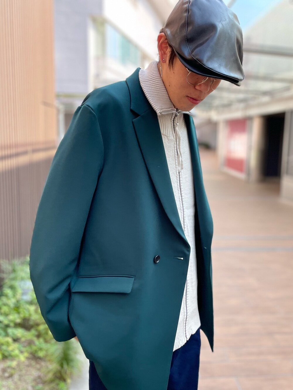 ブラック系のブーツ、ブルー系のデニムパンツ、グリーン系のテーラードジャケットを着用したメンズの秋コーディネートの4枚目の写真