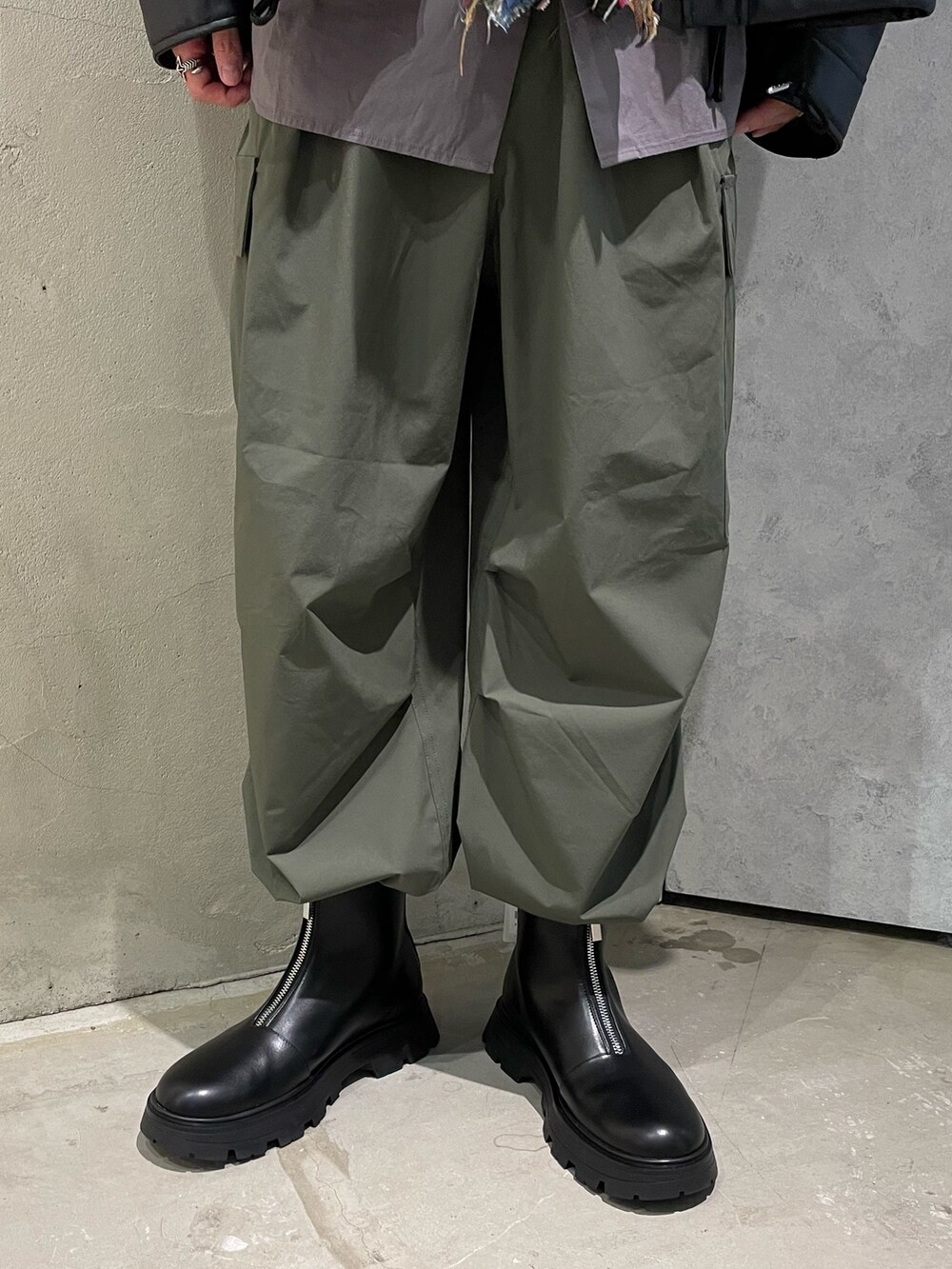 ブラック系のライダースジャケット、ベージュ系のシャツ/ブラウス、グリーン系のカーゴパンツを着用したメンズの秋コーディネートの3枚目の写真