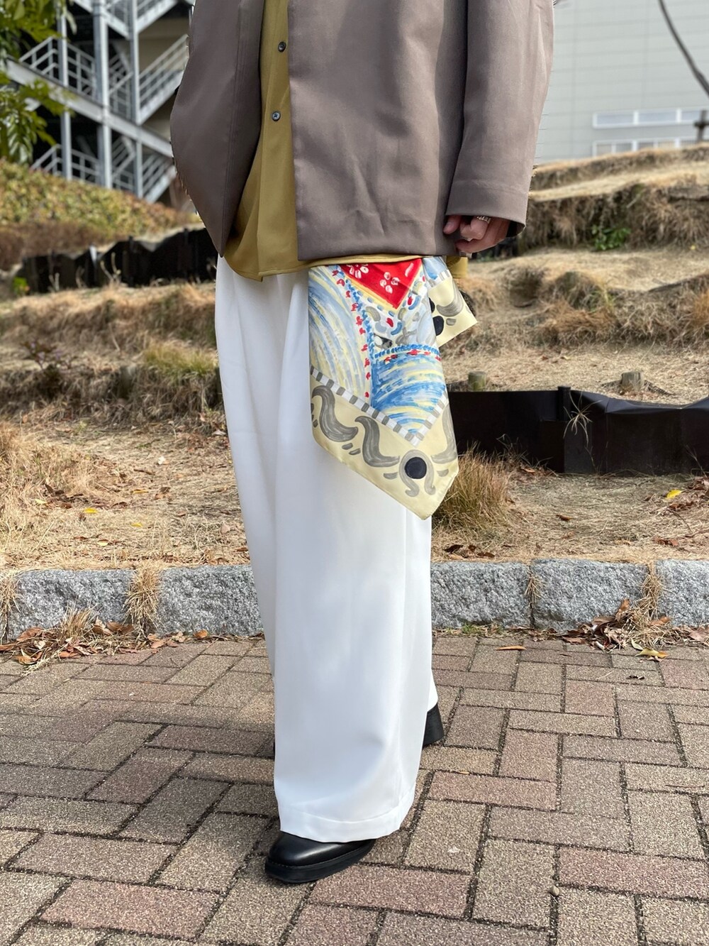 ブラウン系のノーカラージャケット、イエロー系のシャツ/ブラウス、ホワイト系のその他パンツを着用したメンズの冬コーディネートの2枚目の写真