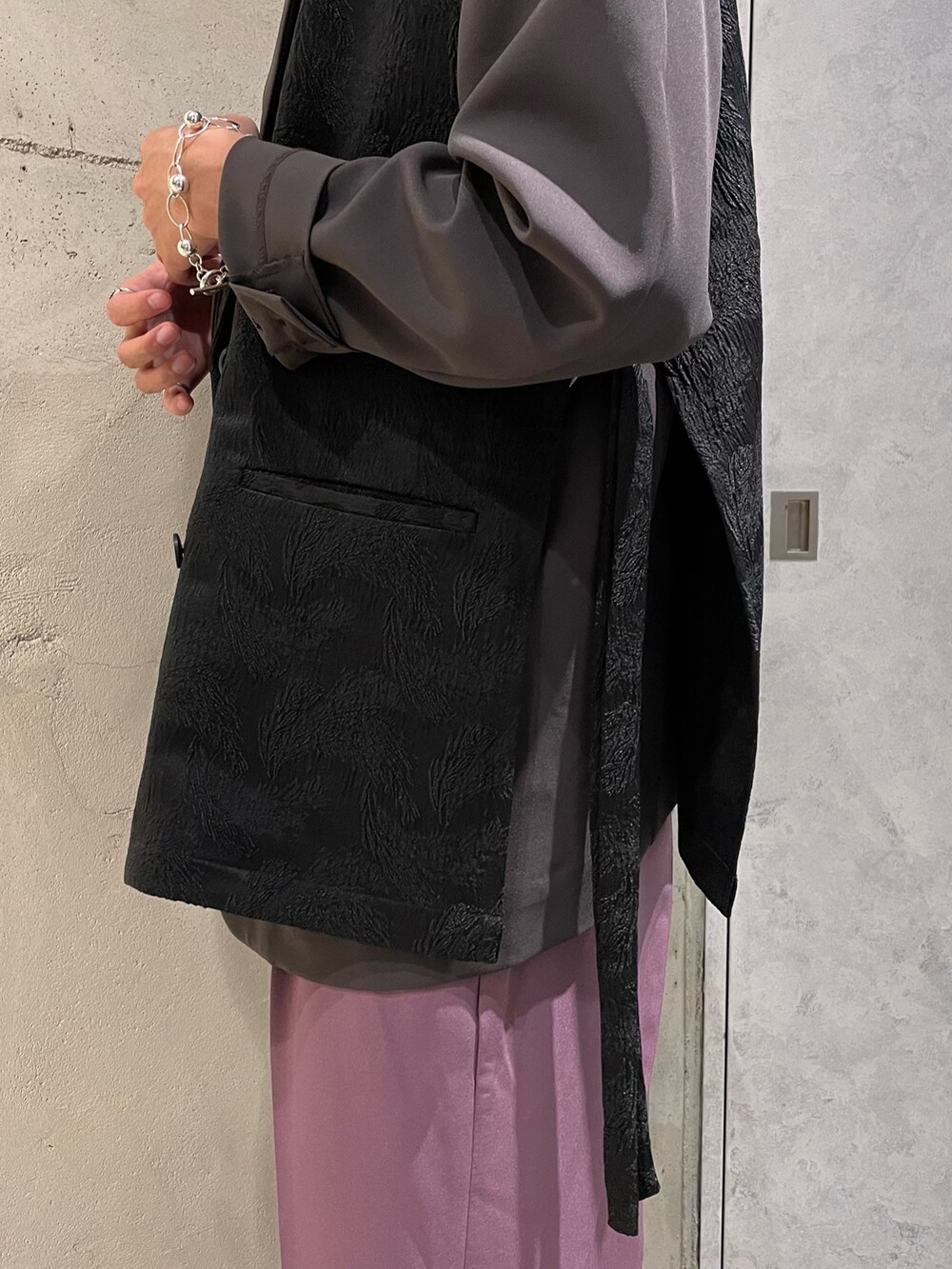 パープル系のスラックス、ブラック系のベスト、ブラウン系のテーラードジャケットを着用したメンズの夏コーディネートの5枚目の写真