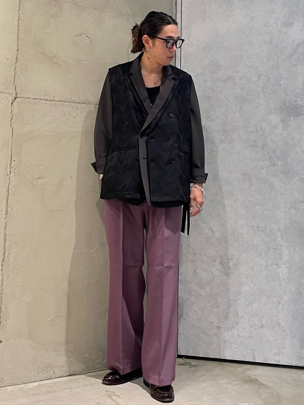 パープル系のスラックス、ブラック系のベスト、ブラウン系のテーラードジャケットを着用したメンズの夏コーディネートの2枚目の写真