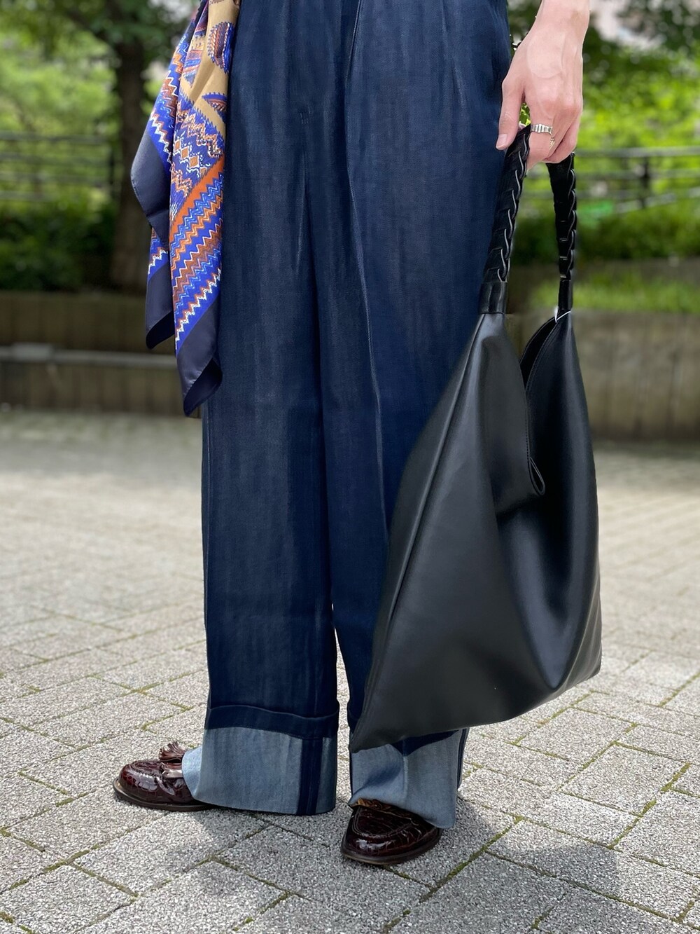 ブルー系のベスト、ブルー系のデニムパンツ、ブラック系のハンドバッグを着用したメンズの夏コーディネートの4枚目の写真