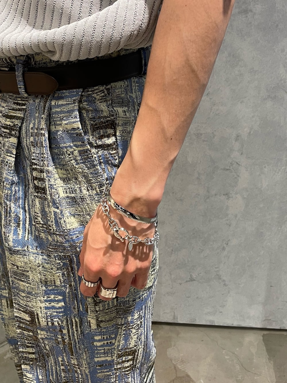 グレー系のポロシャツ、ブルー系のその他パンツ、ブラック系のベルトを着用したメンズの夏コーディネートの3枚目の写真