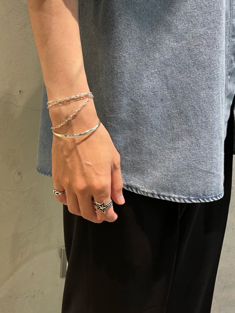 ブルー系のシャツ/ブラウス、ブラック系のスラックス、シルバー系のブレスレットを着用したメンズの夏コーディネートの3枚目の写真