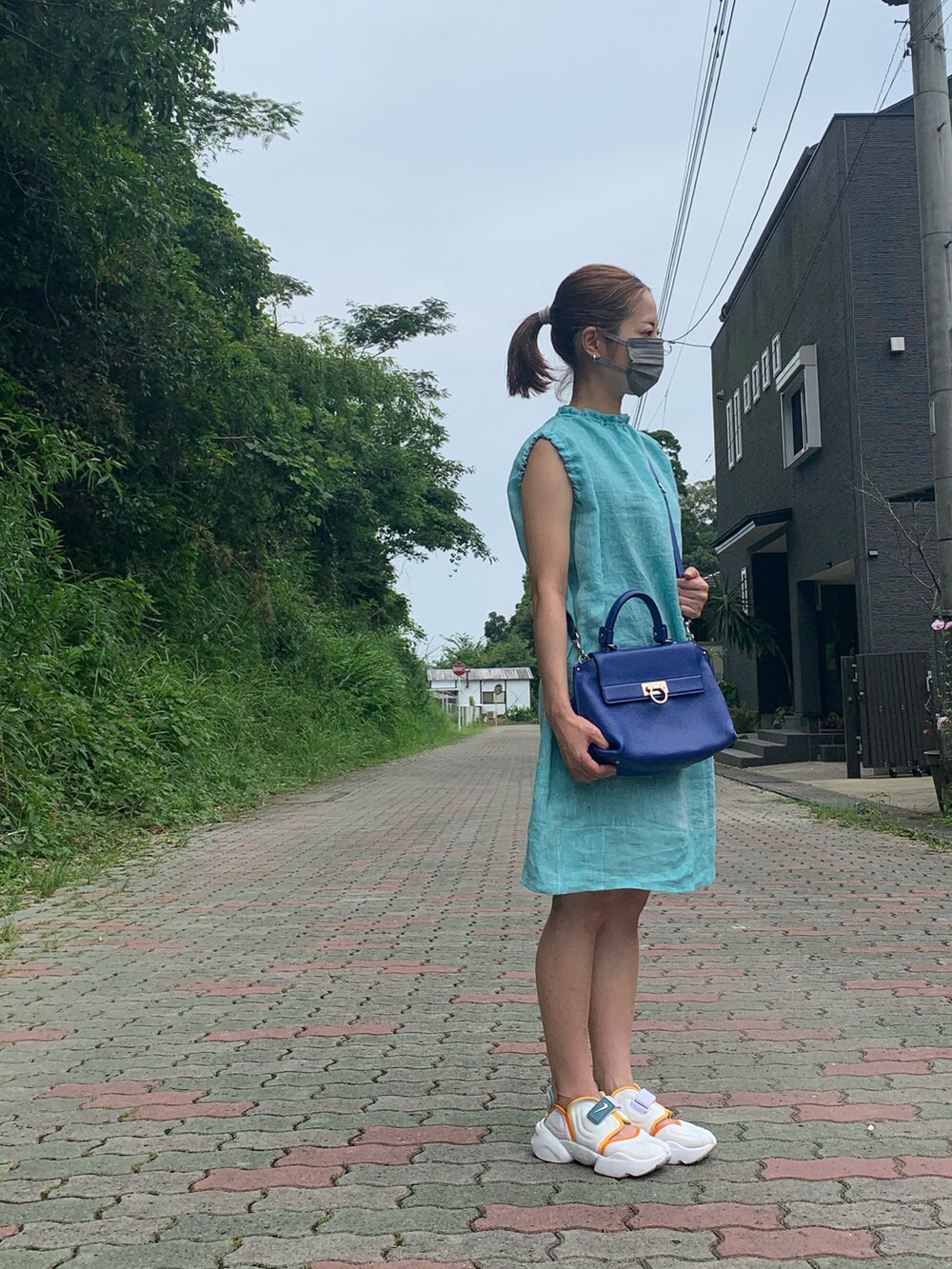 ブルー系のワンピース、ブルー系のバッグ、ホワイト系のサンダルを着用したレディースの夏コーディネートの2枚目の写真