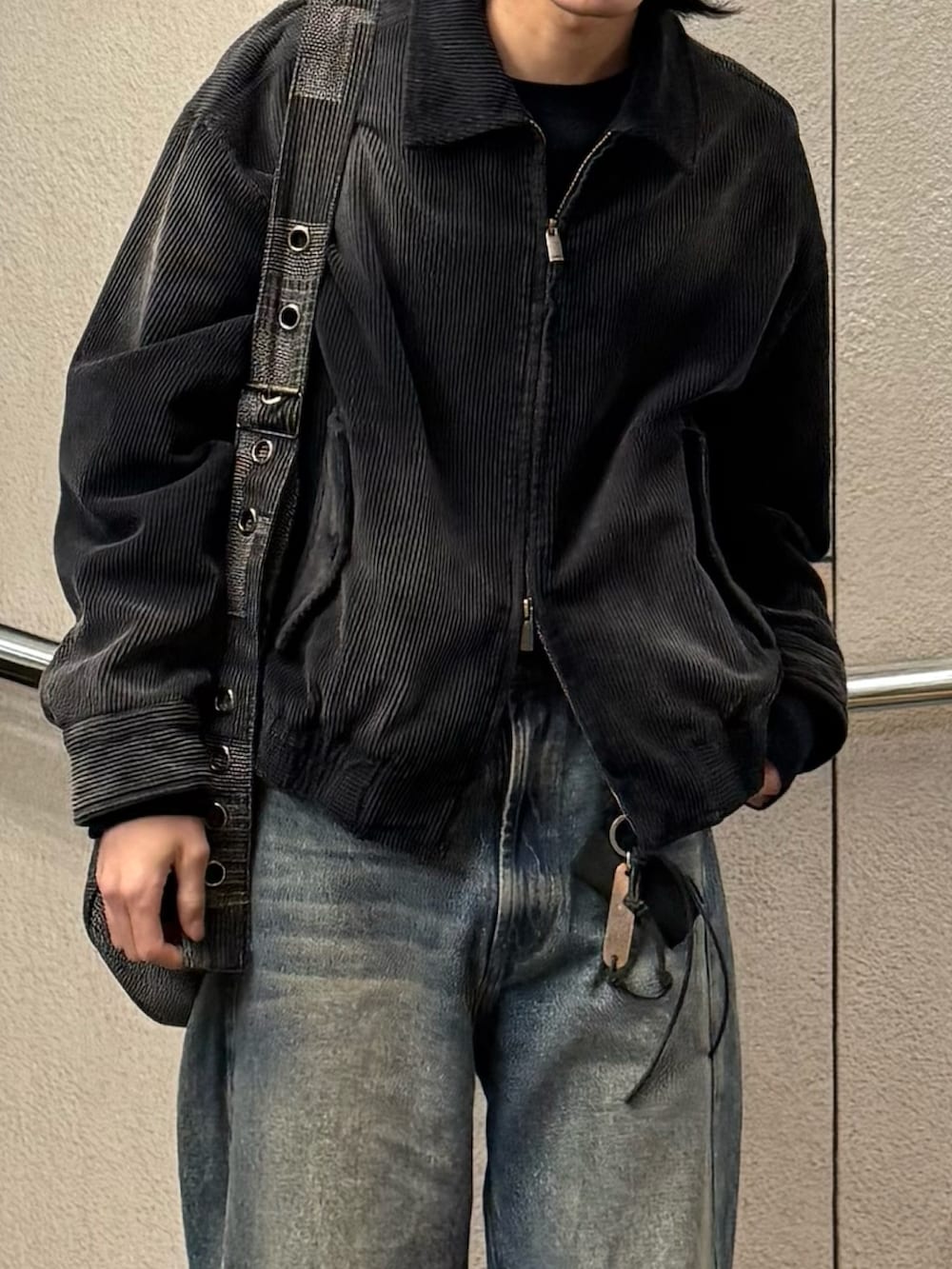 ブルー系のデニムパンツ、ブラック系のドレスシューズ、ブラック系のブルゾンを着用したメンズの春コーディネートの3枚目の写真