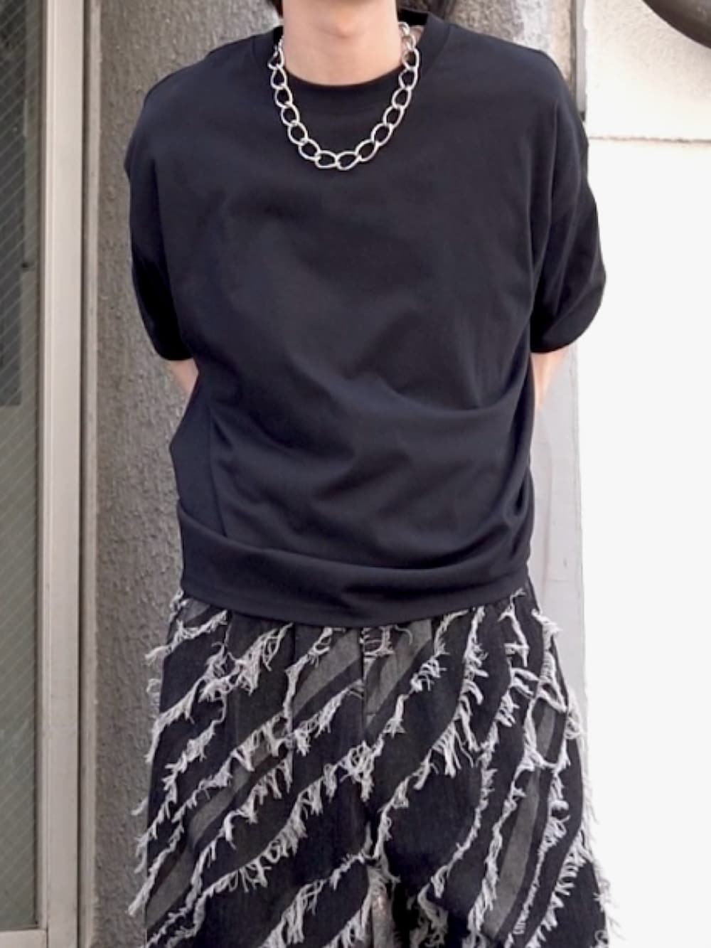 ブラック系のTシャツ/カットソー、グレー系のデニムパンツ、ブラック系のスニーカーを着用したメンズの春コーディネートの2枚目の写真