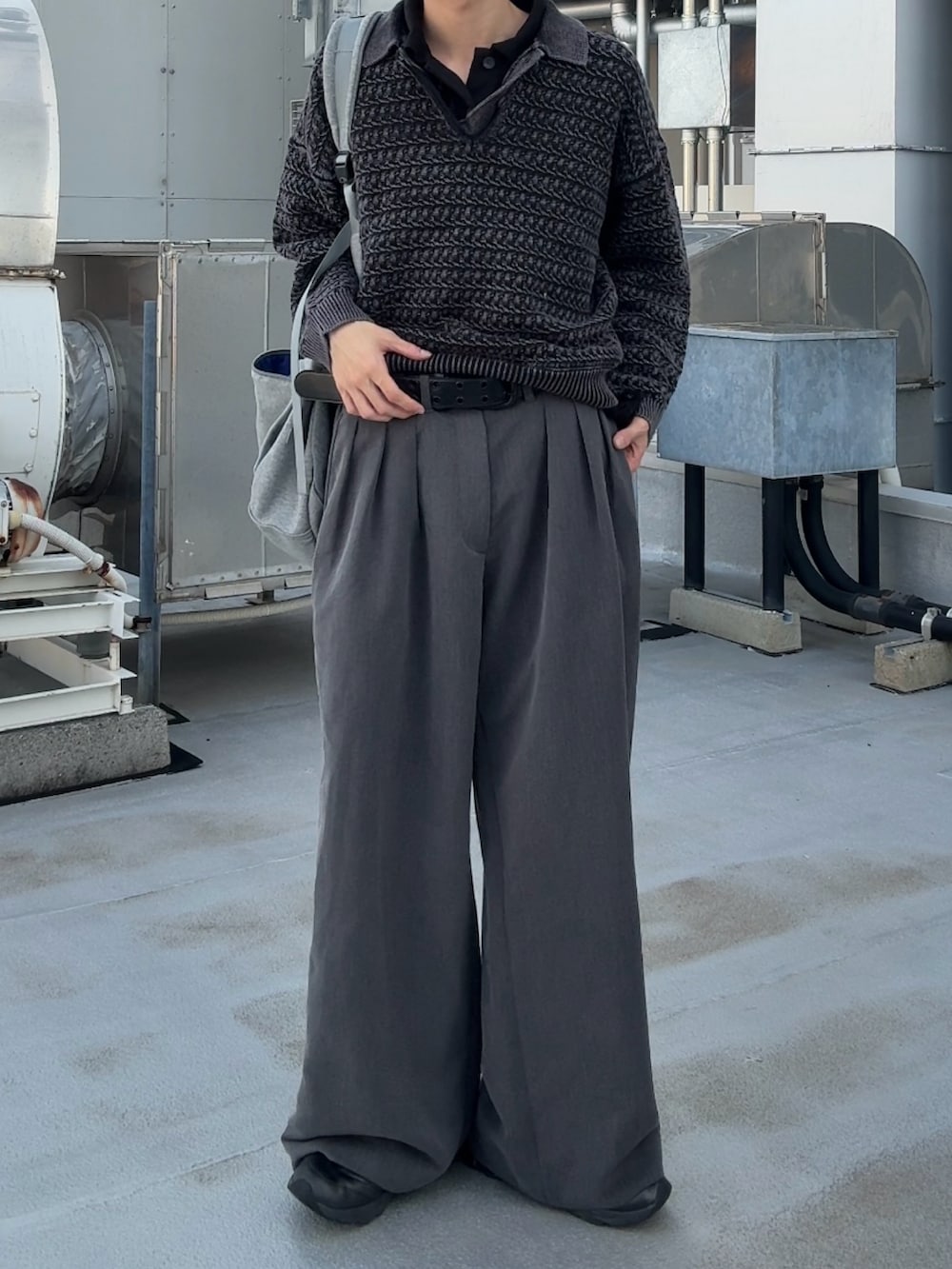 グレー系のショルダーバッグ、グレー系のニット/セーター、グレー系のスラックスを着用したメンズの秋コーディネートの2枚目の写真