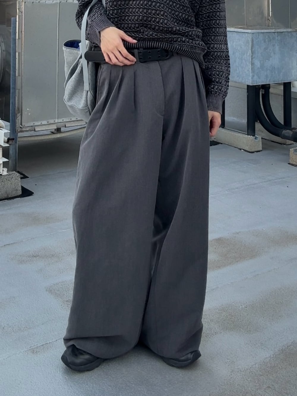 グレー系のショルダーバッグ、グレー系のニット/セーター、グレー系のスラックスを着用したメンズの秋コーディネートの4枚目の写真