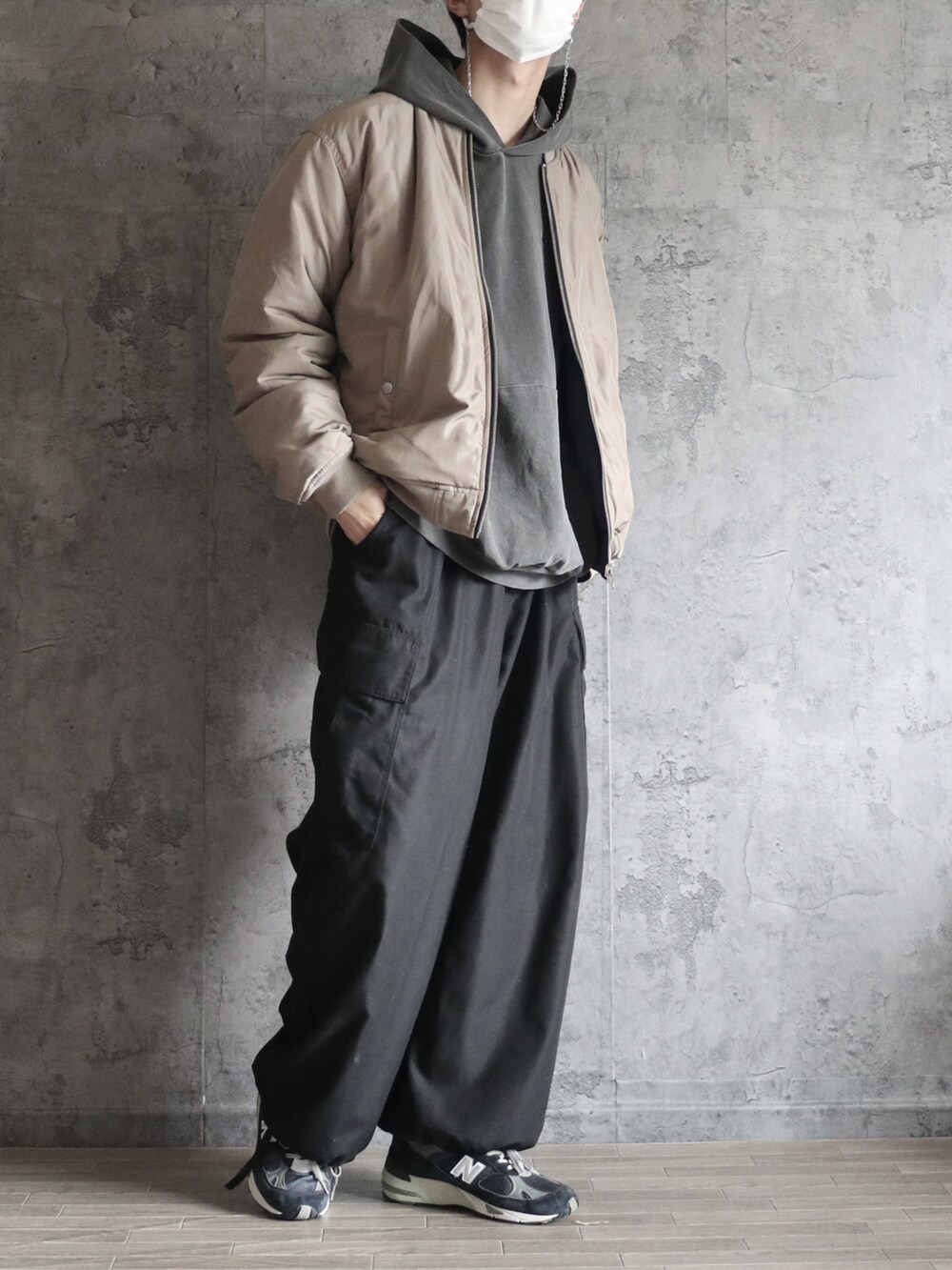 グレー系のパーカー、ブラック系のその他パンツ、ベージュ系のMA-1を着用したメンズの冬コーディネートの2枚目の写真