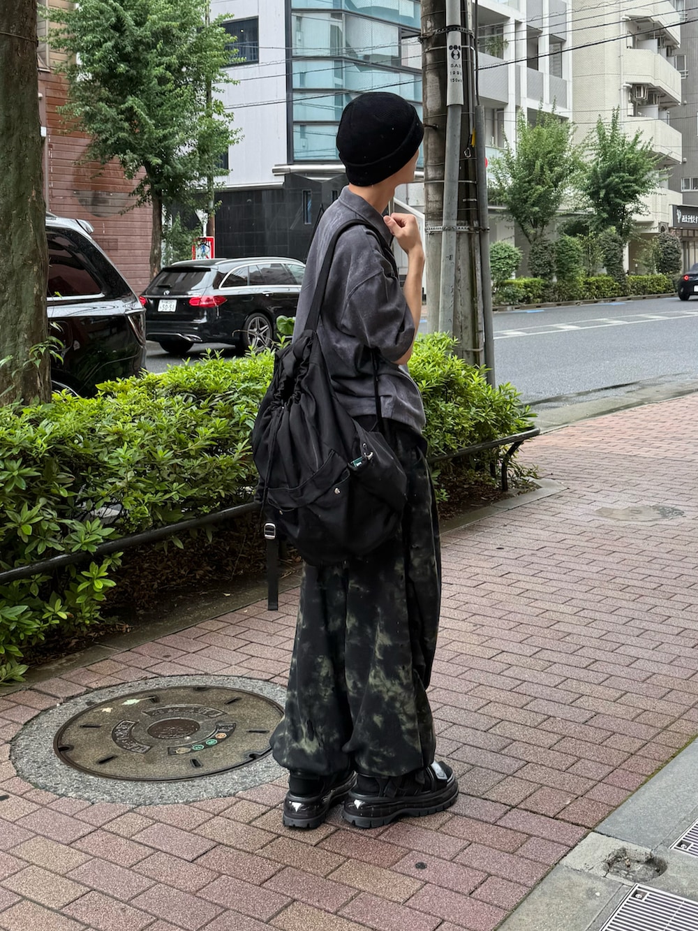 ブラック系のポロシャツ、ブラック系のスウェットパンツ、ブラック系のサンダルを着用したメンズの夏コーディネートの2枚目の写真