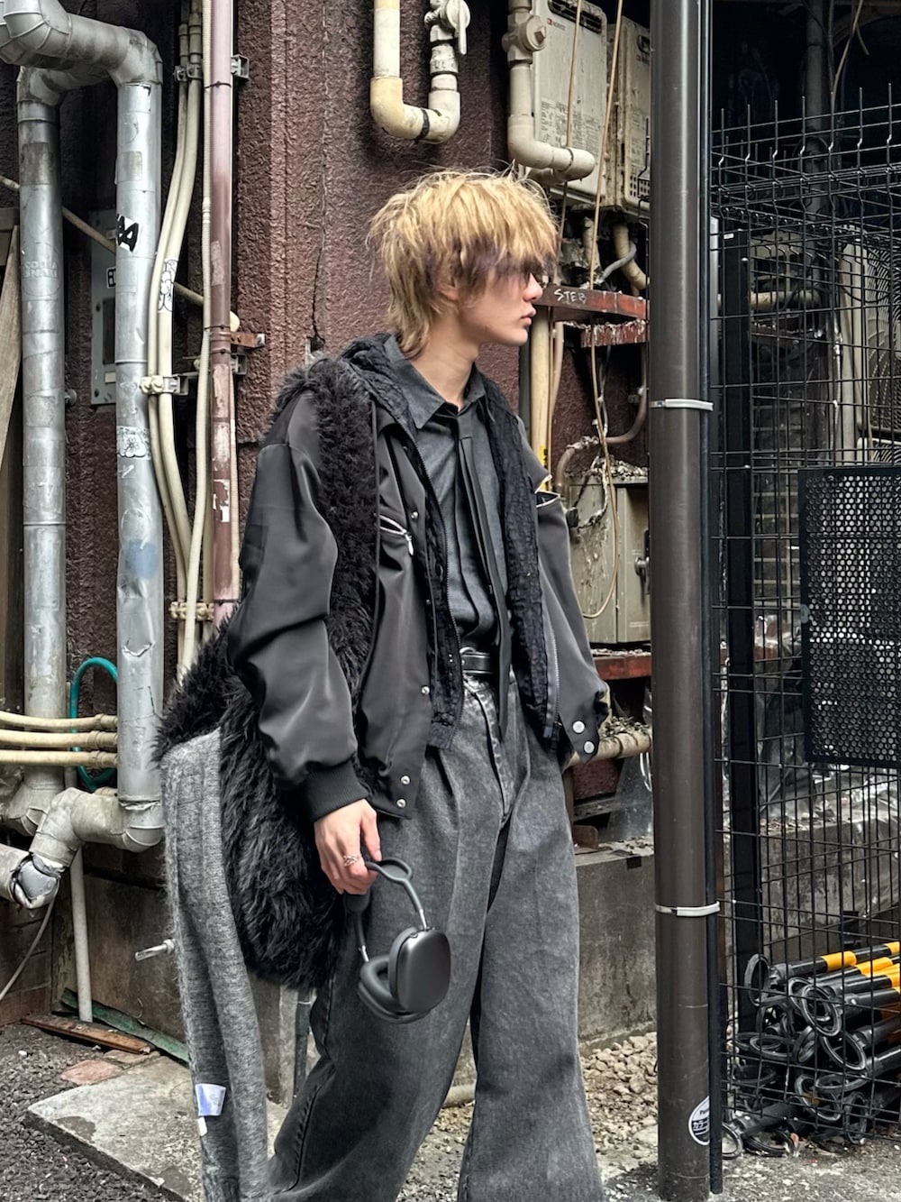 ブラック系のスタジャン、ブラック系のパーカー、グレー系のデニムパンツを着用したメンズの春コーディネートの2枚目の写真