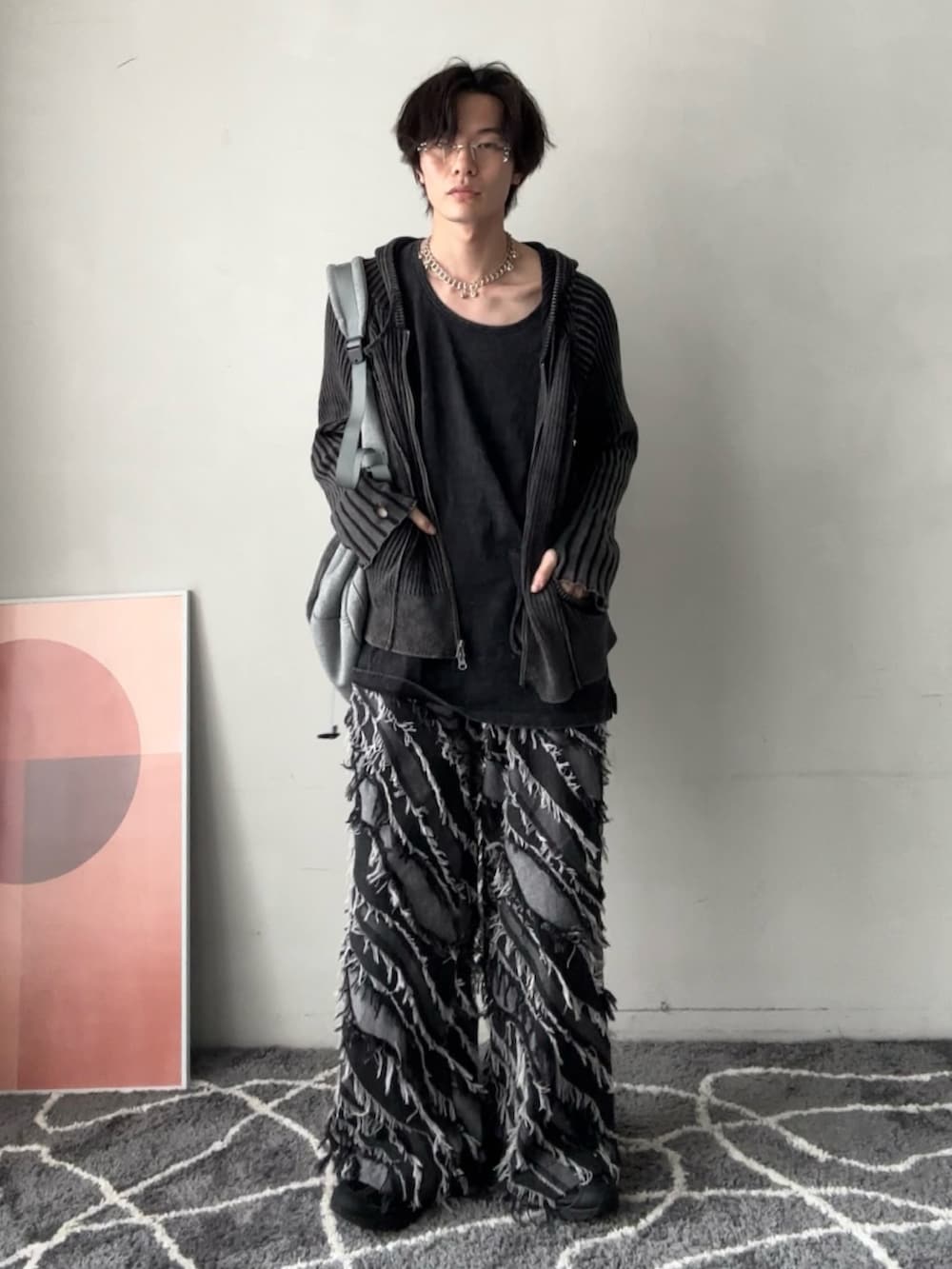 ブラック系のニット/セーター、グレー系のショルダーバッグ、ブラック系のタンクトップを着用したメンズの春コーディネートの2枚目の写真