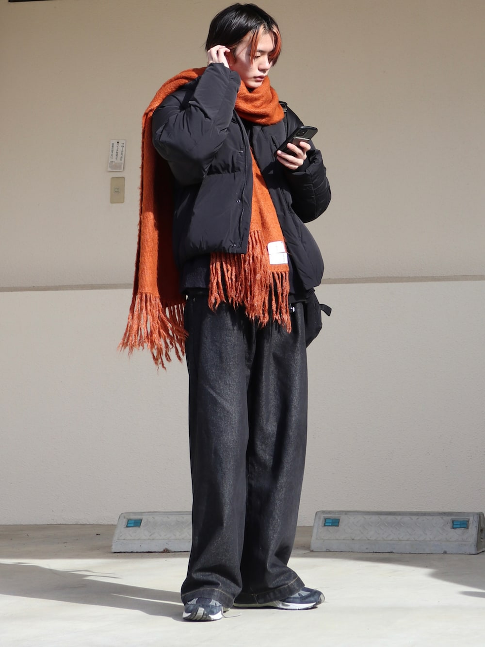 ブラック系のデニムパンツ、ブルー系のカーディガン/ボレロ、ブラック系のダウンジャケット/コートを着用したメンズの冬コーディネートの3枚目の写真