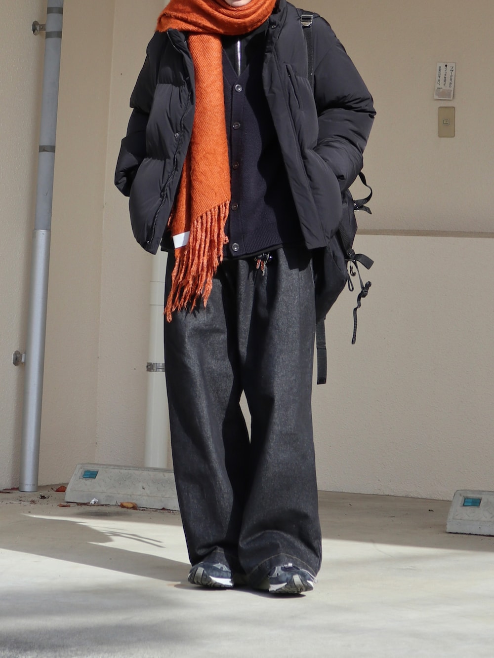 ブラック系のデニムパンツ、ブルー系のカーディガン/ボレロ、ブラック系のダウンジャケット/コートを着用したメンズの冬コーディネートの2枚目の写真