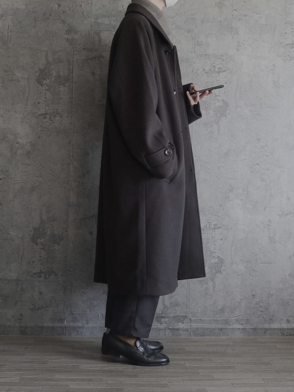 ベージュ系のニット/セーター、グレー系のセットアップ、グレー系のステンカラーコートを着用したメンズの秋コーディネートの2枚目の写真