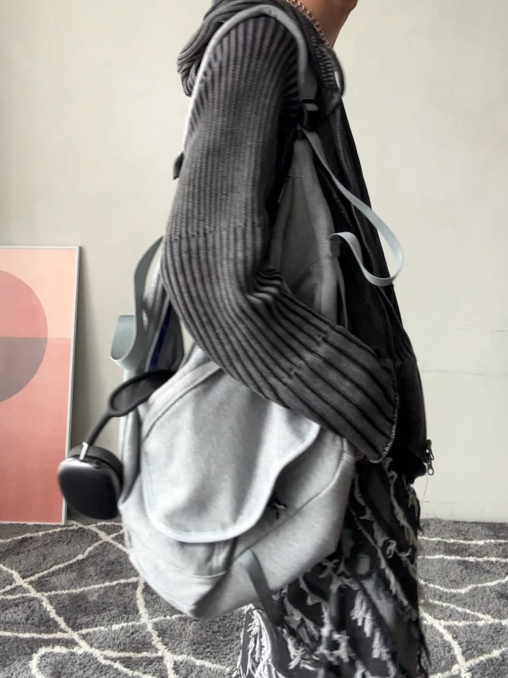 ブラック系のニット/セーター、グレー系のショルダーバッグ、ブラック系のタンクトップを着用したメンズの春コーディネートの3枚目の写真