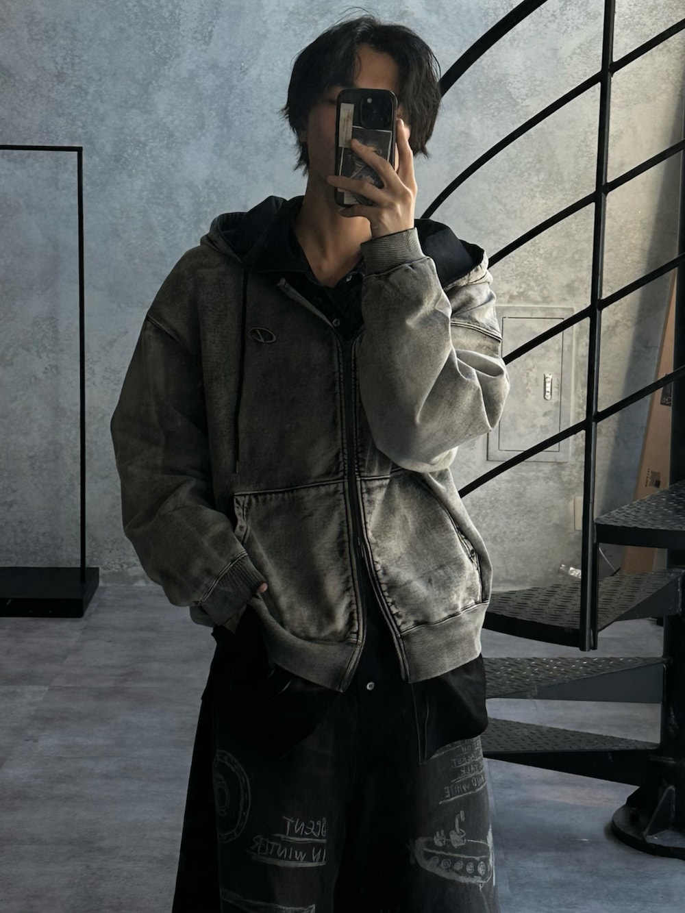 ブラック系のパーカー、ブラック系のマウンテンパーカー、ブラック系のデニムパンツを着用したメンズの冬コーディネートの3枚目の写真