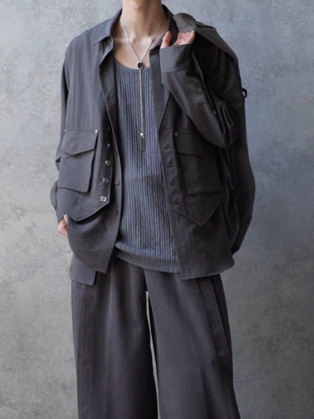 グレー系のシャツ/ブラウス、グレー系のスラックス、シルバー系のスニーカーを着用したメンズの春コーディネートの2枚目の写真