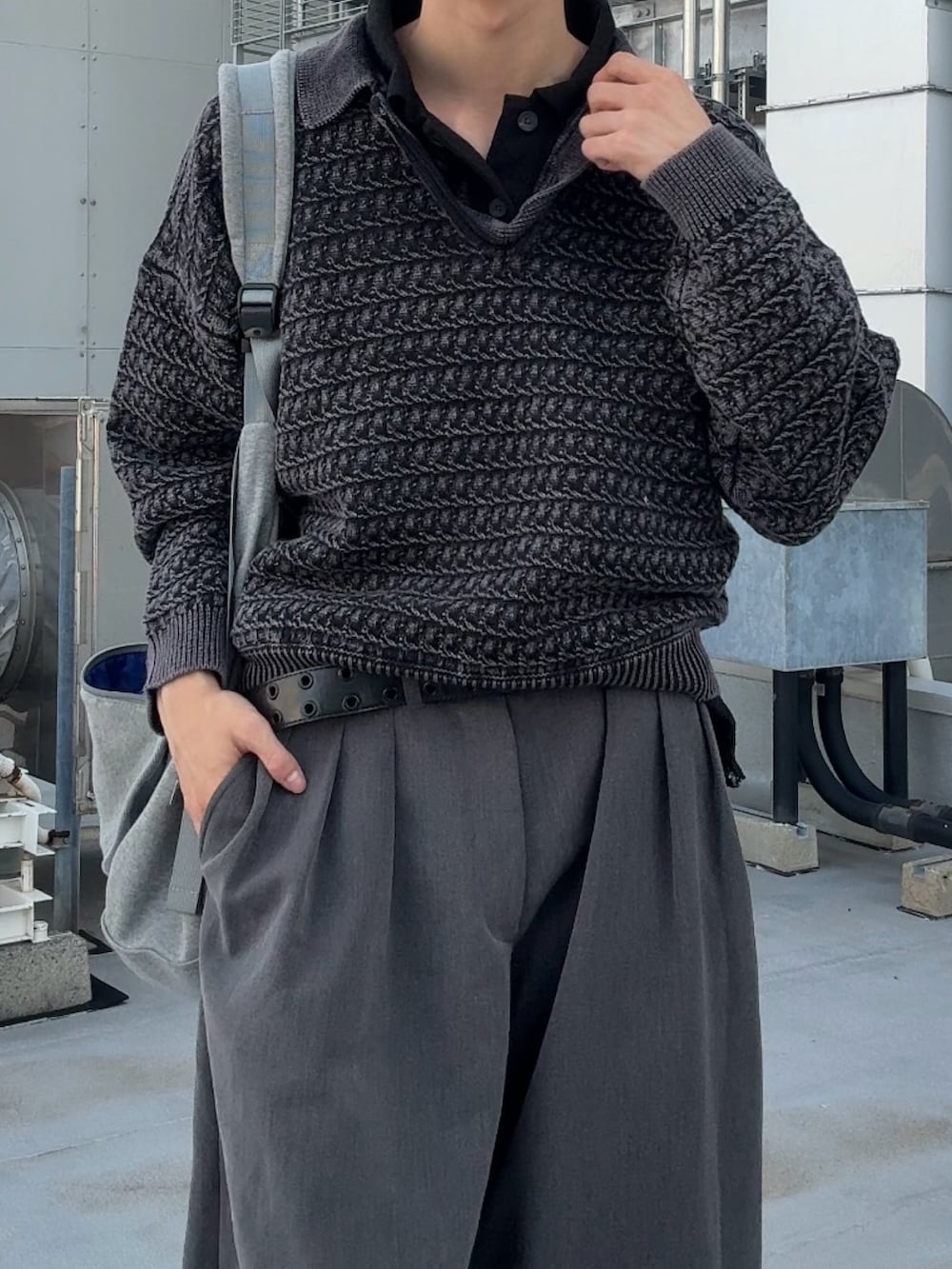 グレー系のショルダーバッグ、グレー系のニット/セーター、グレー系のスラックスを着用したメンズの秋コーディネートの3枚目の写真