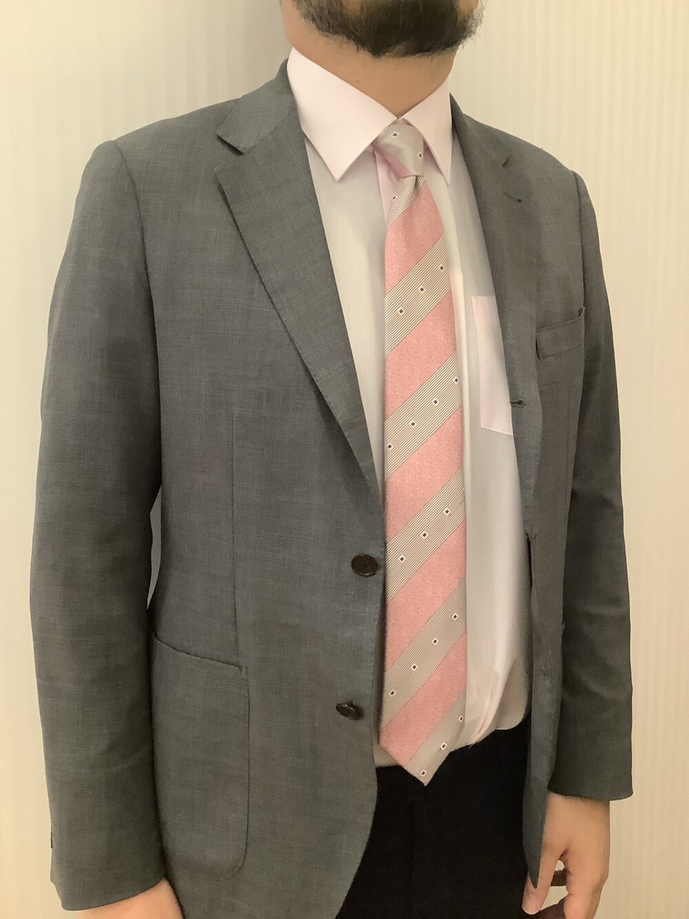 ピンク系のビジネスシャツ、ピンク系のネクタイ、ブルー系のバックパック/リュックを着用したメンズの春コーディネートの2枚目の写真