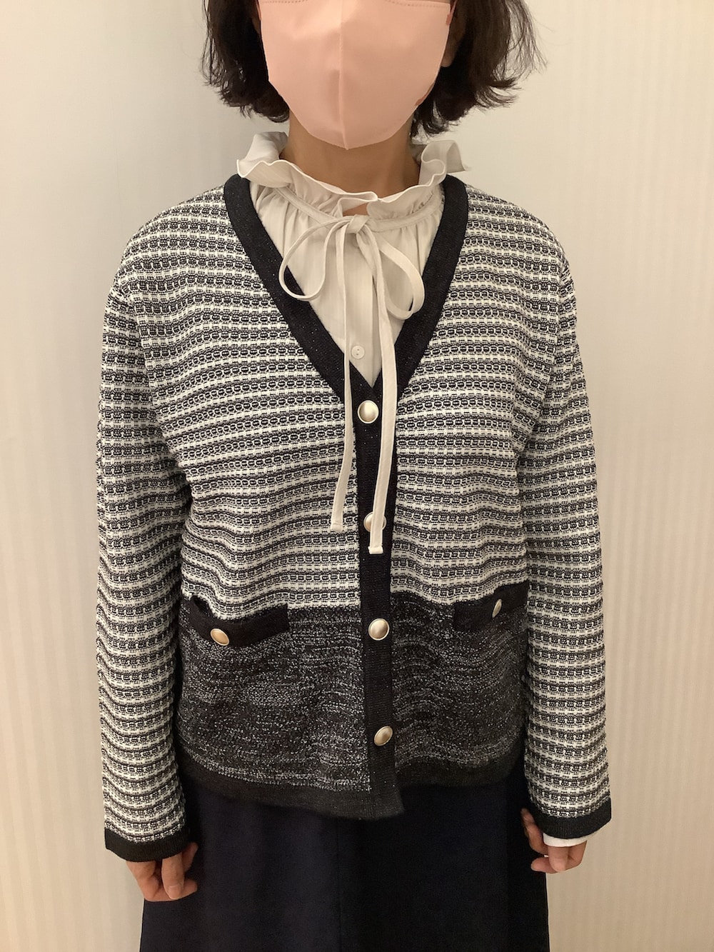 ブラック系のノーカラージャケット、ベージュ系のシャツ/ブラウスを着用したレディースの冬コーディネートの2枚目の写真