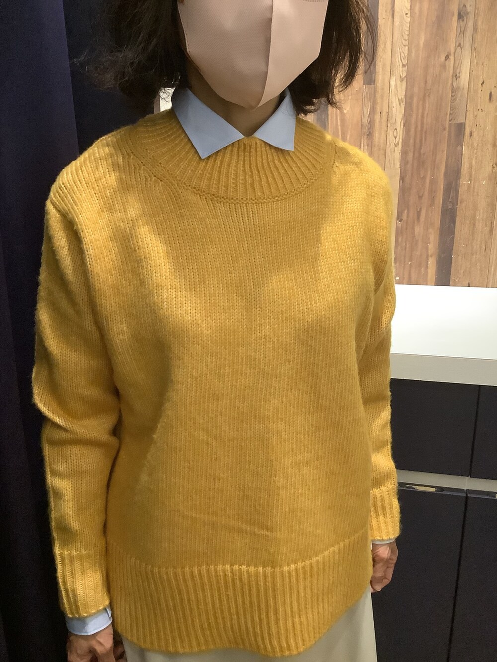 ブルー系のビジネスシャツ、イエロー系のニット/セーター、オレンジ系のストール/ショールを着用したレディースの冬コーディネートの3枚目の写真