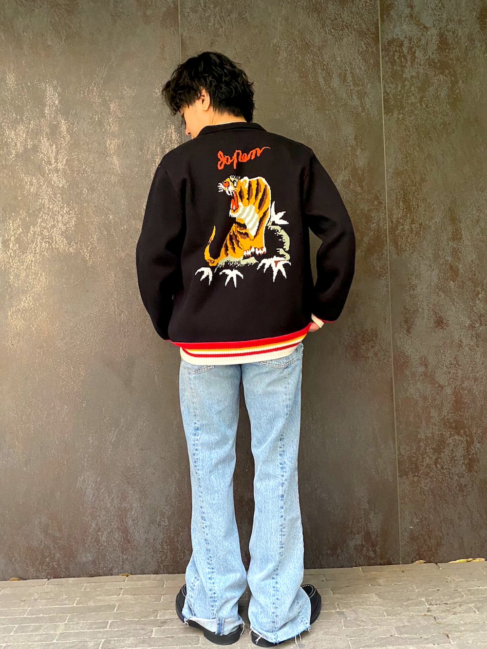 ブルー系のデニムパンツ、ブラック系のブーツ、ホワイト系のTシャツ/カットソーを着用したメンズの春コーディネートの2枚目の写真