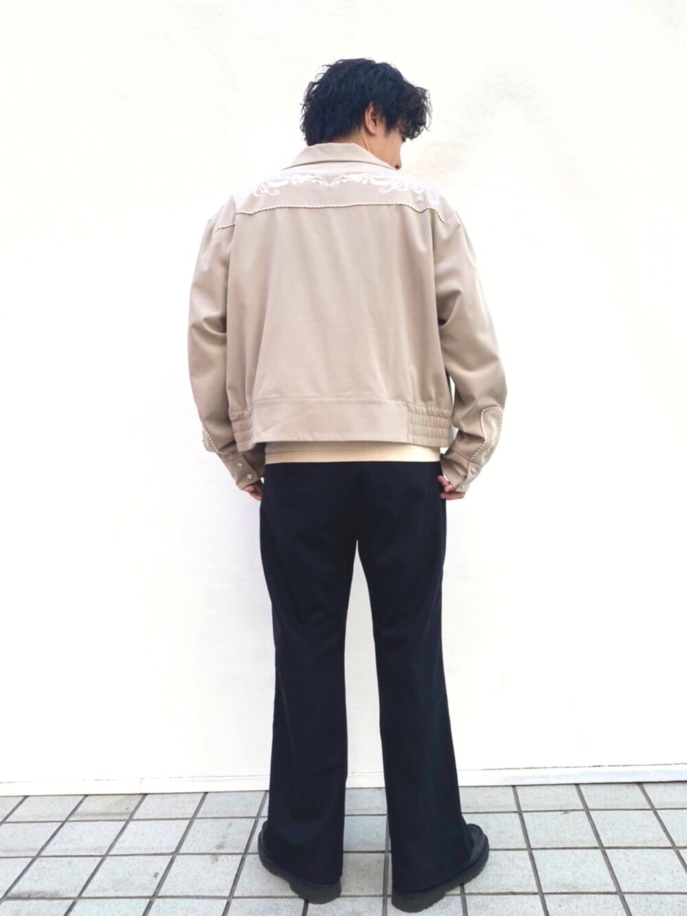 ベージュ系のTシャツ/カットソー、ベージュ系のその他アウター、ブラック系のスラックスを着用したメンズの春コーディネートの2枚目の写真