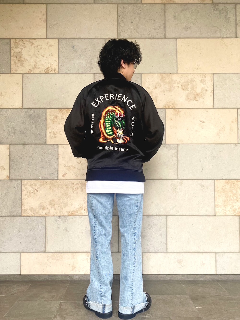 ブルー系のデニムパンツ、ブラック系のブーツ、ホワイト系のタンクトップを着用したメンズの春コーディネートの2枚目の写真